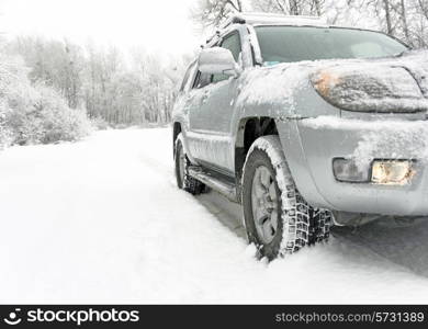 Snowy winter road behind an unrecognizable car