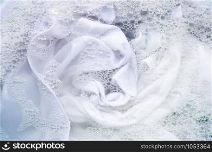 Soak white clothes in powder detergent water dissolution. Laundry concept