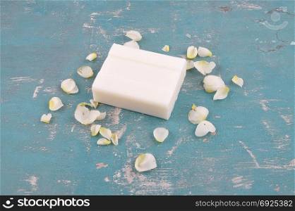 Soap and rose petals on weathered background