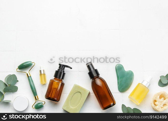 Soap, eucalyptus, aroma oil,  spa objects on white tile background. Top view. Skin care, body treatment concept. 