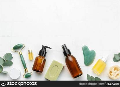 Soap, eucalyptus, aroma oil,  spa objects on white tile background. Top view. Skin care, body treatment concept. 