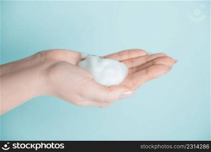 Soap foam in the hand. Coronavirus prevention concept, antiseptic on a blue background.. Soap foam in the hand. Coronavirus prevention, antiseptic on a blue background.