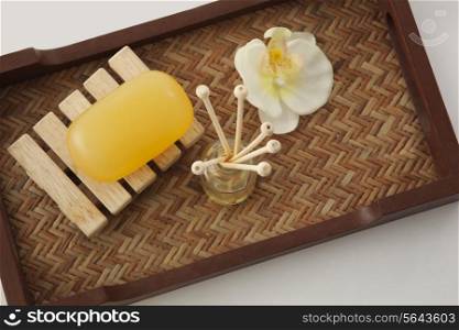 Soap , reed diffuser and orchid in a tray