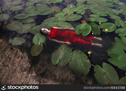 Soar in the water. Attractive sensual girl in water with water lily