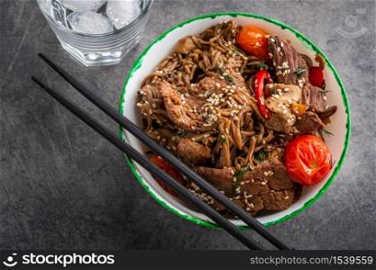 Soba noodles with beef, mushrooms, cherry tomato and sweet peppers. Asian cuisine.