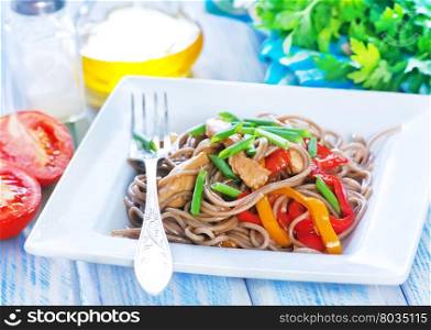 soba with vegetables in the bowl and on a table
