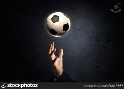 Soccer ball in palm. Close up of elegant businessman holding soccer ball in hand