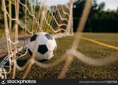 Soccer ball in the gate net, nobody. Football on outdoor stadium, sport game or goal concept. Soccer ball in the gate net, nobody