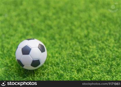 Soccer ball on grass green field with copy space