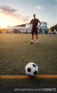 Soccer ball on line, player on the field on background. Footballer on outdoor stadium, workout before game, football training