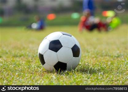 Soccer ball on the grass and coach children&#xA;
