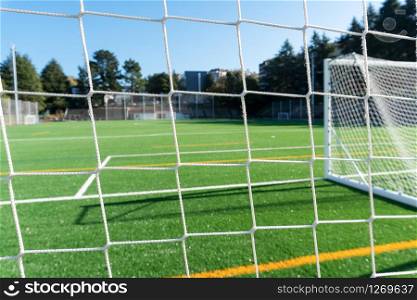 Soccer court net and gate with artificial turf field. Soft focus background
