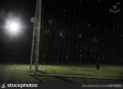 soccer football goal keeper in night with falling rain