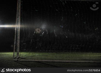 soccer football goal keeper in night with falling rain