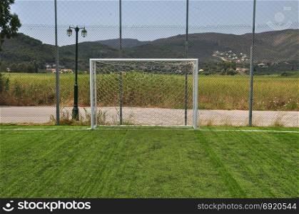 Soccer goalpost and net in empty sports field.