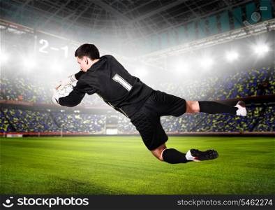 soccer or football goalkeeper is catching ball on stadium. goalkeeper