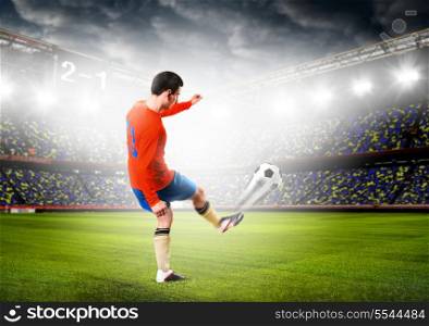 soccer or football player is kicking ball on stadium. soccer player