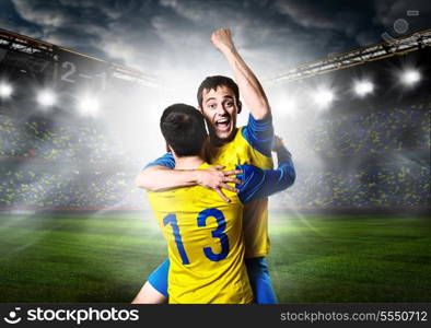 soccer or football players are celebrating goal on stadium. soccer players
