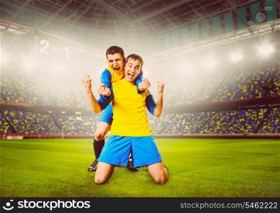 soccer or football players are celebrating goal on stadium, warm colors toned