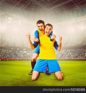 soccer or football players are celebrating goal on stadium, warm colors toned