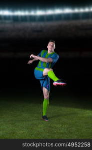 soccer player doing kick with ball on football stadium field