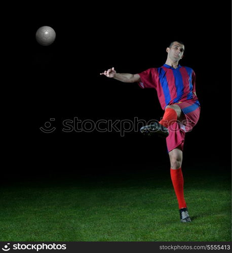 soccer player doing kick with ball on football stadium field isolated on black background