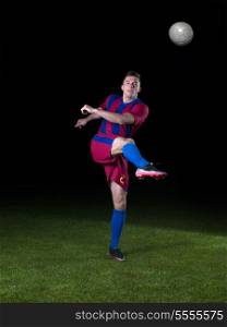 soccer player doing kick with ball on football stadium field isolated on black background