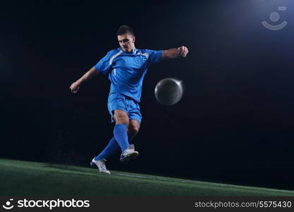 soccer player doing kick with ball on football stadium field isolated on black background