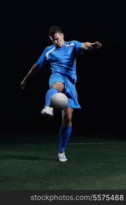 soccer player doing kick with ball on football stadium field isolated on black background