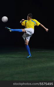 soccer player doing kick with ball on football stadium field isolated on black background