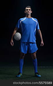 soccer player doing kick with ball on football stadium field isolated on black background