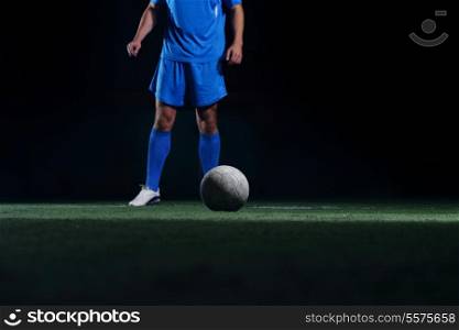 soccer player doing kick with ball on football stadium field isolated on black background