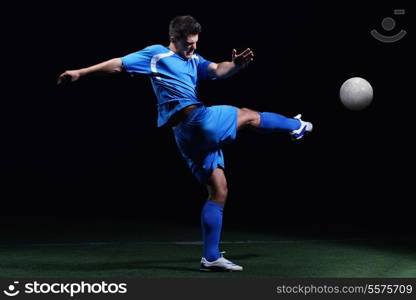 soccer player doing kick with ball on football stadium field isolated on black background