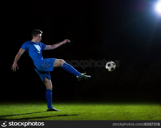 soccer player doing kick with ball on football stadium field isolated on black background