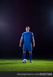 soccer player doing kick with ball on football stadium field isolated on black background