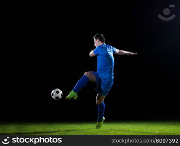 soccer player doing kick with ball on football stadium field isolated on black background