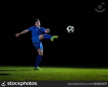 soccer player doing kick with ball on football stadium field isolated on black background