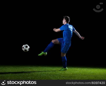 soccer player doing kick with ball on football stadium field isolated on black background