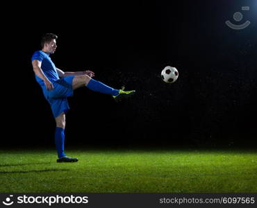 soccer player doing kick with ball on football stadium field isolated on black background