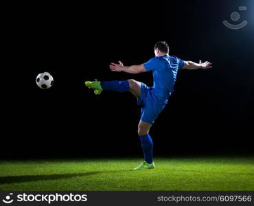 soccer player doing kick with ball on football stadium field isolated on black background