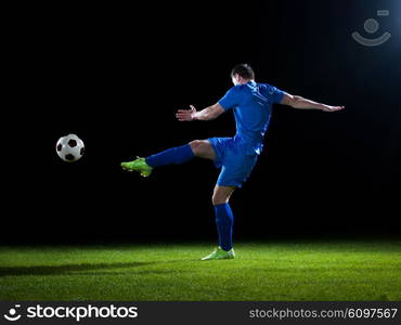 soccer player doing kick with ball on football stadium field isolated on black background