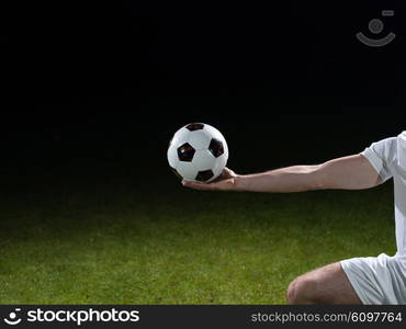 soccer player doing kick with ball on football stadium field isolated on black background