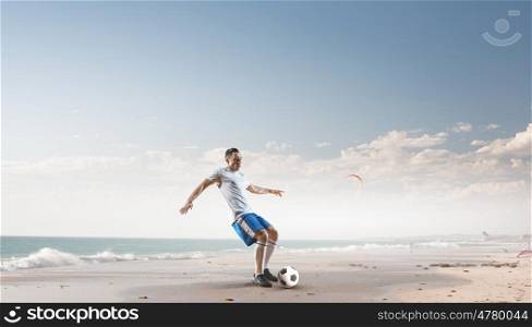 Soccer player hitting ball. Football player with ball in action at ocean coast