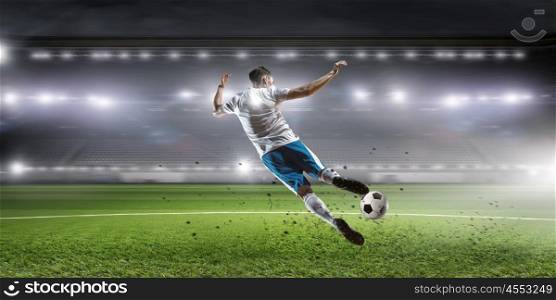 Soccer player hitting ball. Football player with ball in action at stadium