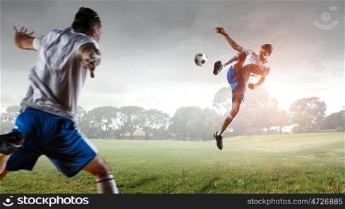 Soccer player hitting ball. Football player with ball in action outdoors