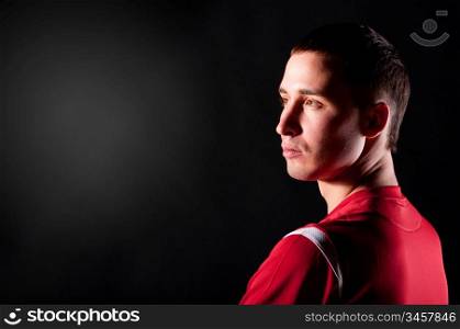 soccer player is looking sideways on black background