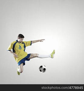 Soccer player. Soccer player kicking ball isolated over white background