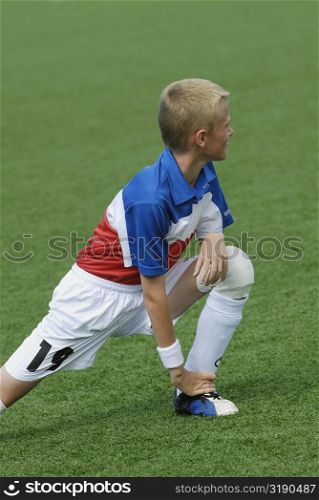 Soccer player stretching in a soccer field