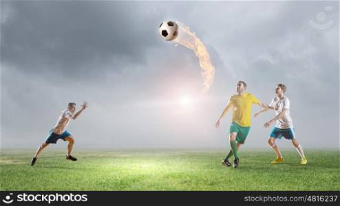 Soccer players fighting for ball. Football players with ball in action at field