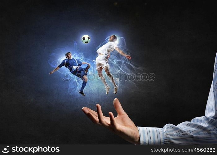 Soccer players fighting for ball. Two soccer players with ball in action in male palm